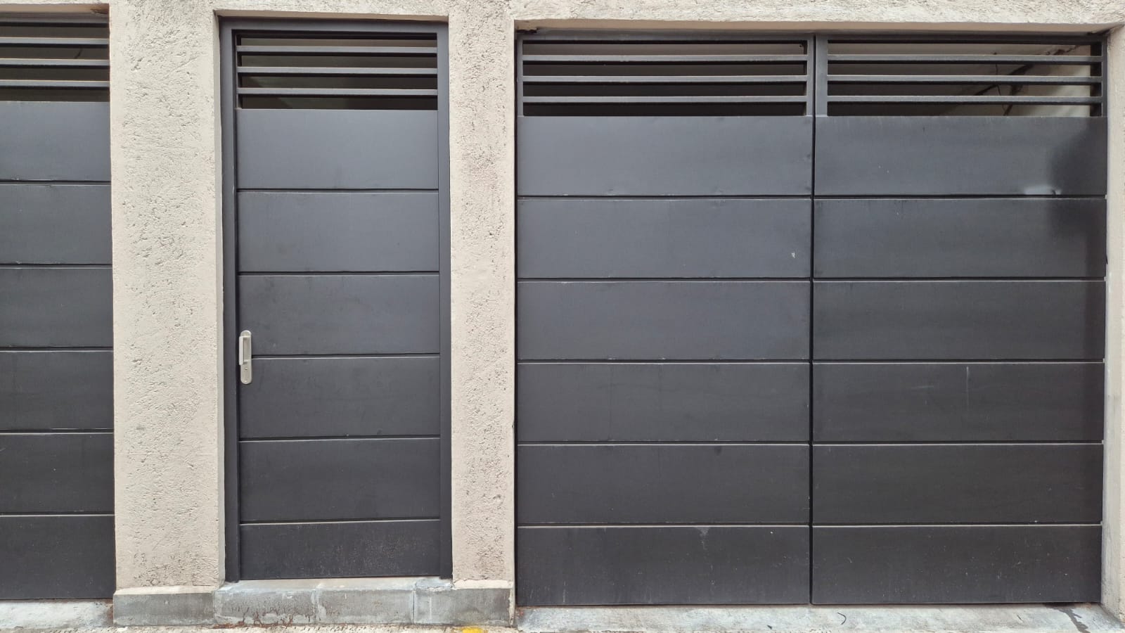 Puerta portón de herrería con ventilación instalada en contexto residencial